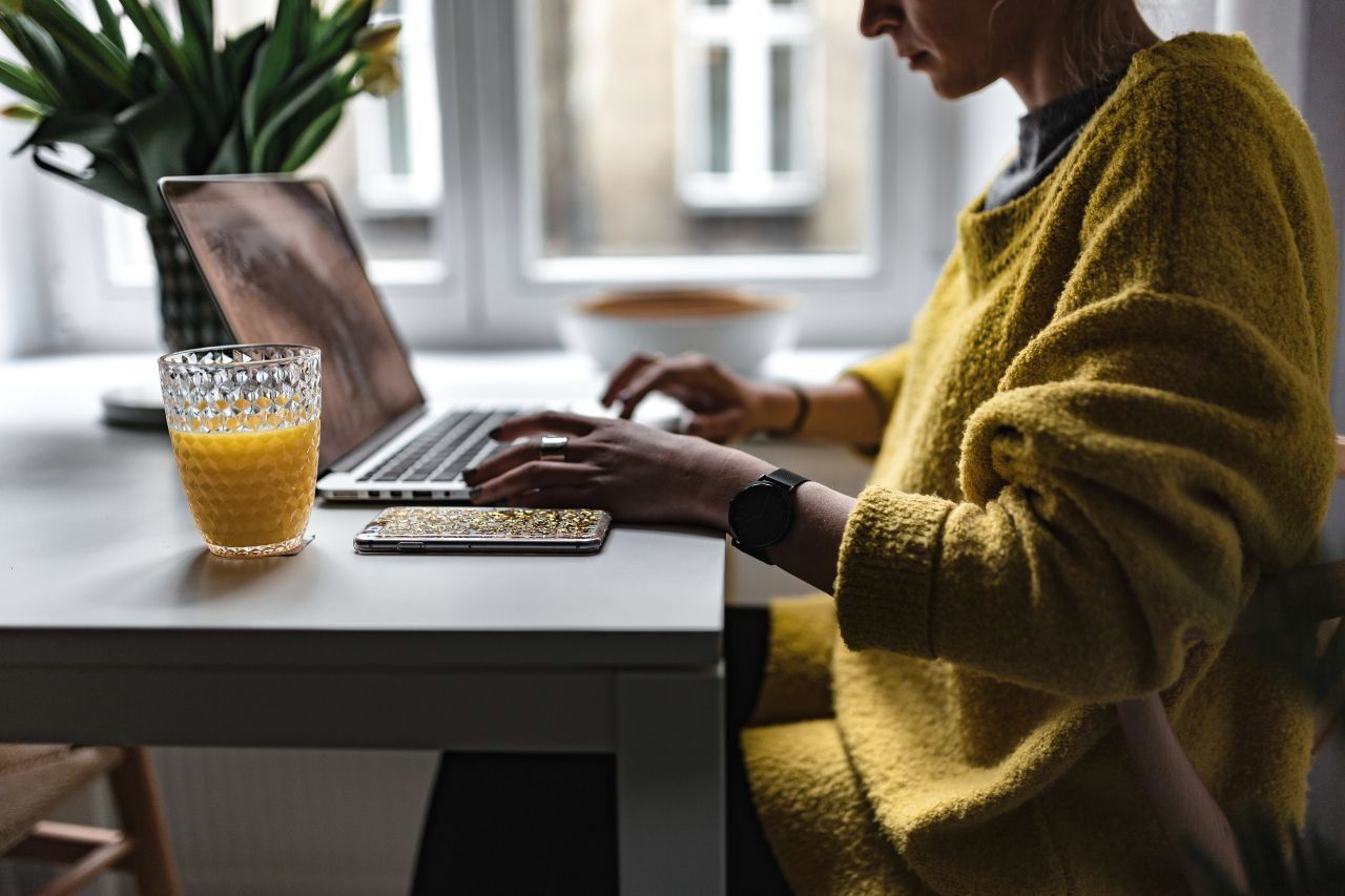 A business owner working on her laptop by a window
