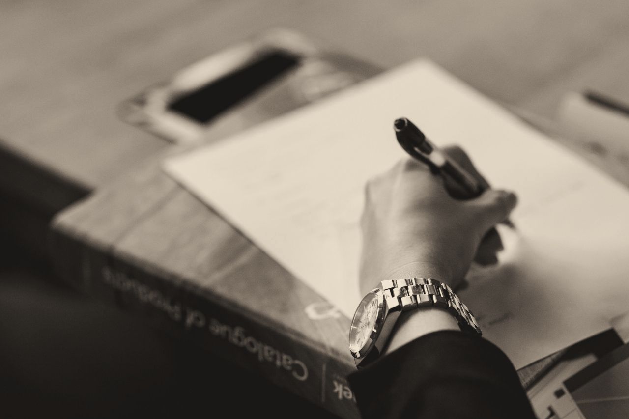 A hand signing a document