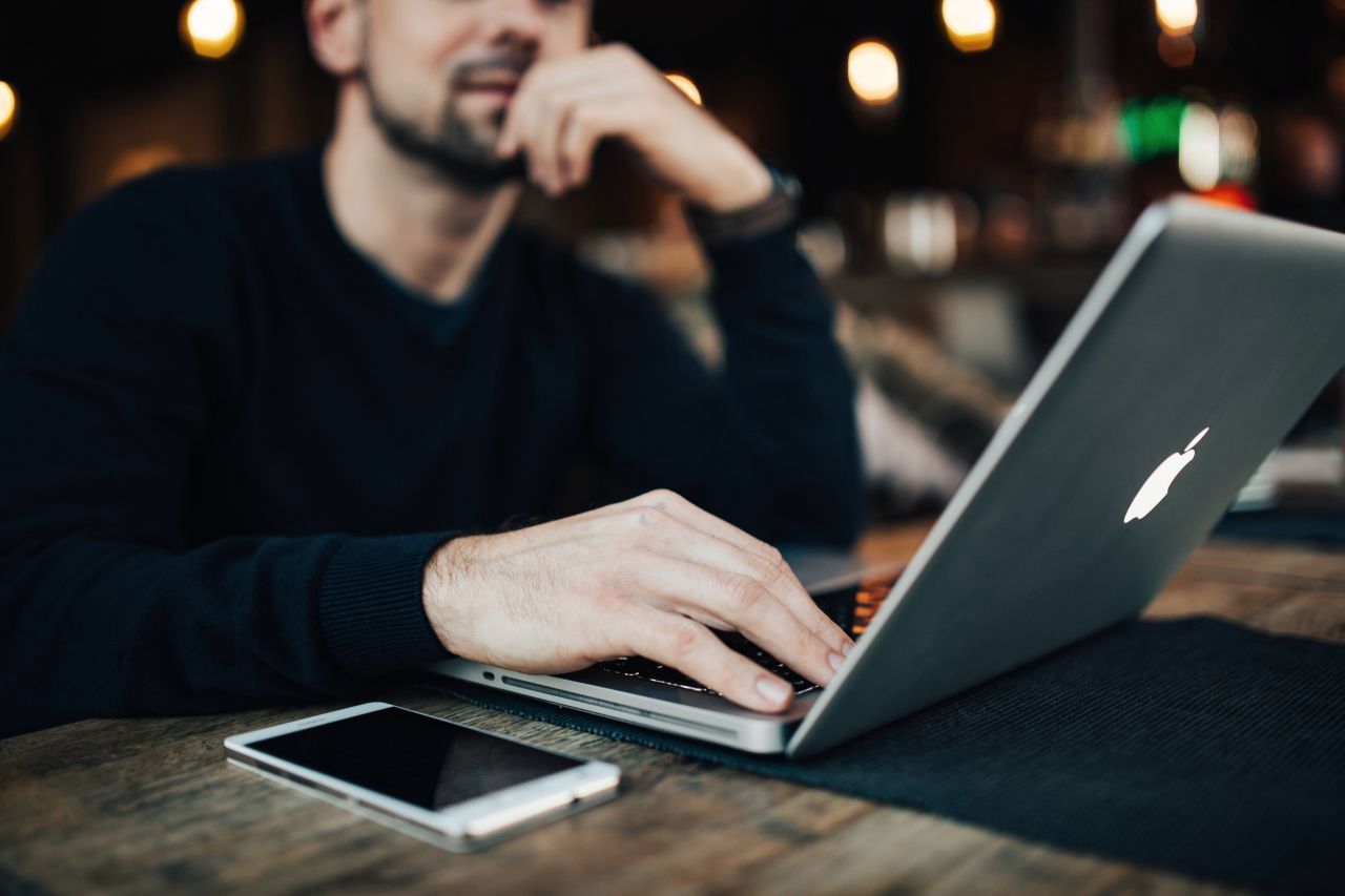 A client smiling during a phone call at his desk